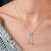 Silver necklace with floral pendant on a person from silvilsu wearing a denim jacket.