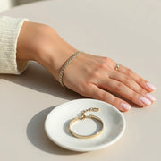 Interlocking chain bracelets on a wrist with soft natural light and a clean neutral background