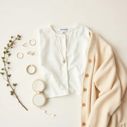 Necklace, earrings, bracelet, and rings styled on casual clothing in soft natural light.