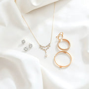 Coordinated bridal jewelry set with necklace and earrings on white satin fabric