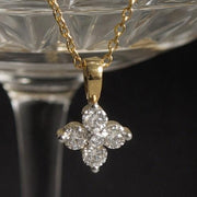 Gold necklace with a diamond pendant on a glass background