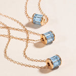 Load image into Gallery viewer, Gold necklaces with blue gemstones on a beige background