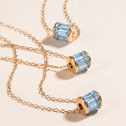 Gold necklaces with blue gemstones on a beige background