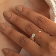 Close-up of a hand wearing a diamond ring with a blurred background