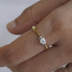 Load image into Gallery viewer, Hand wearing a gold ring with a diamond on a white background
