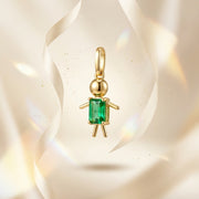 Gold pendant with a green gemstone on a beige background
