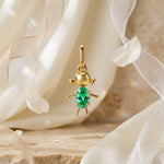 Load image into Gallery viewer, Gold pendant with a green gemstone on a soft fabric background