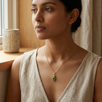 Load image into Gallery viewer, Woman wearing a gold necklace with a green pendant indoors