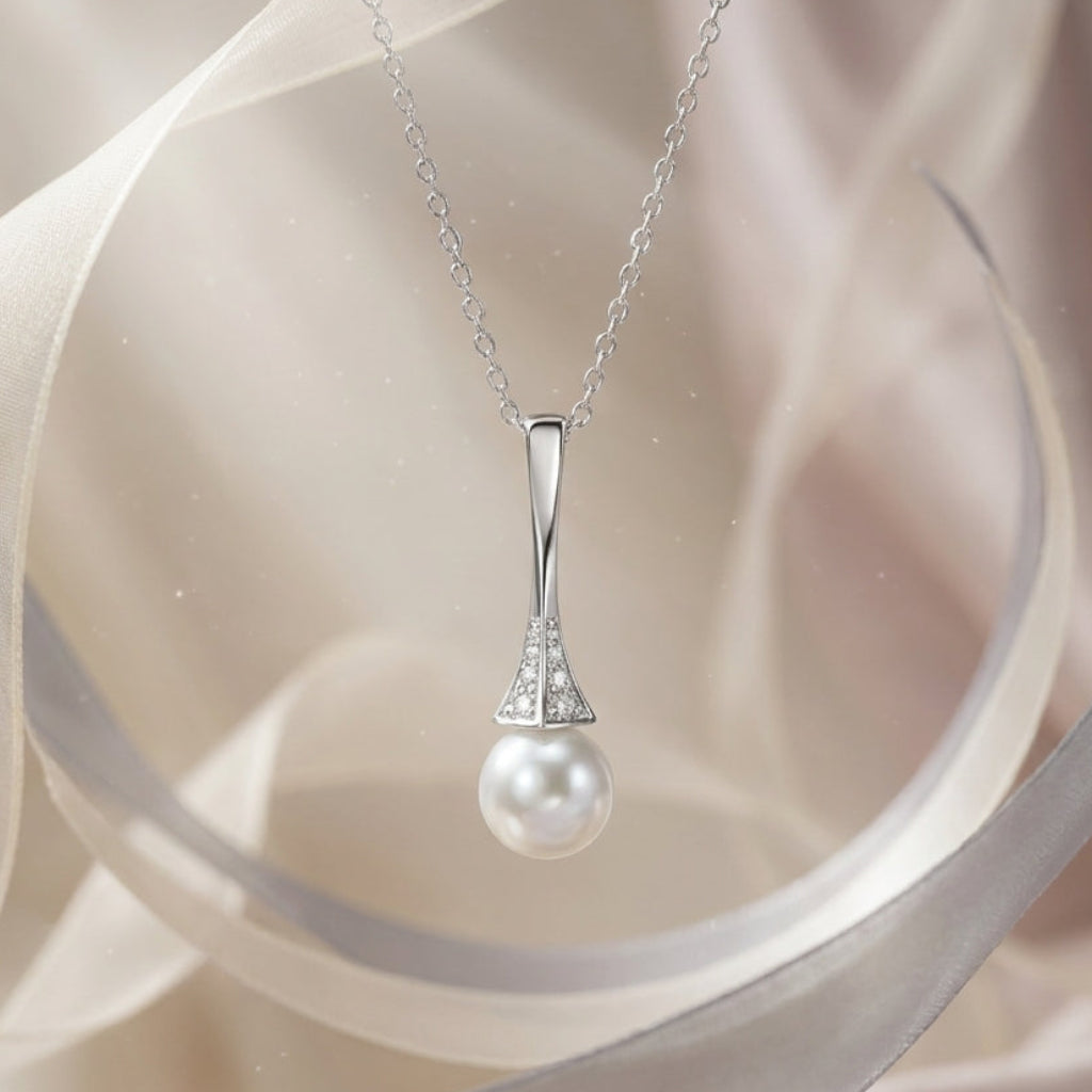 Pearl necklace with silver chain on a soft fabric background