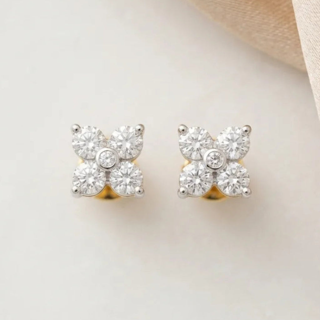 Pair of diamond stud earrings on a light fabric background