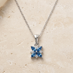 Load image into Gallery viewer, Silver necklace with a blue gemstone pendant on a beige background